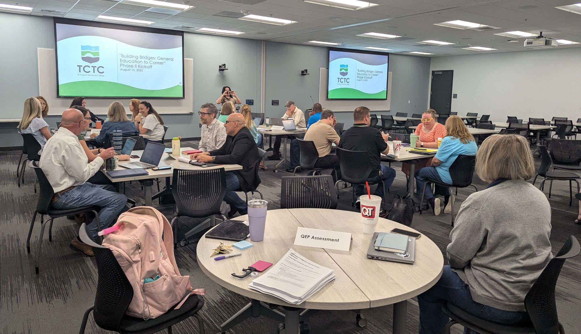 QEP meeting with participants sitting at tables in discussion